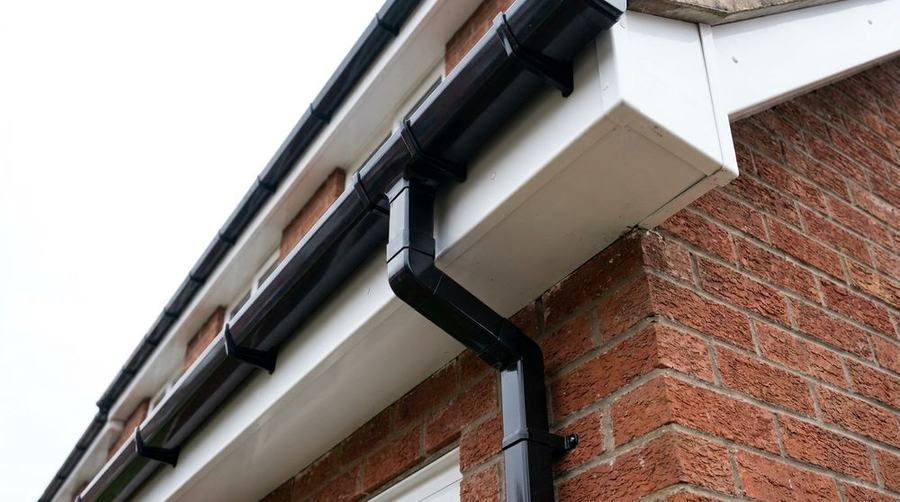 New black uPVC guttering installed on a brick house
