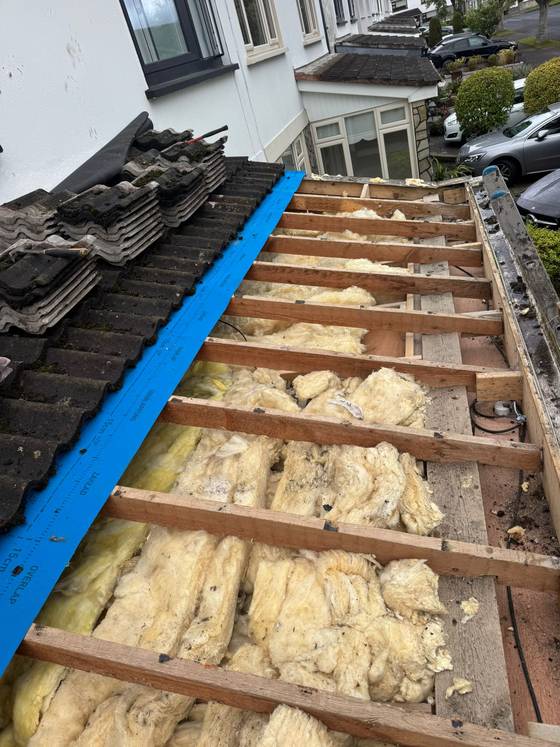 Roof stripped back to battens with insulation visible