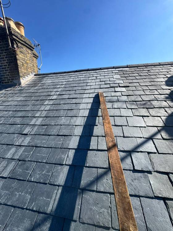 Completed slate roof against a blue sky