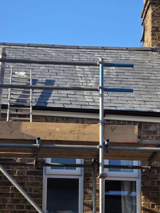 Scaffolded property with new slate roof and timber