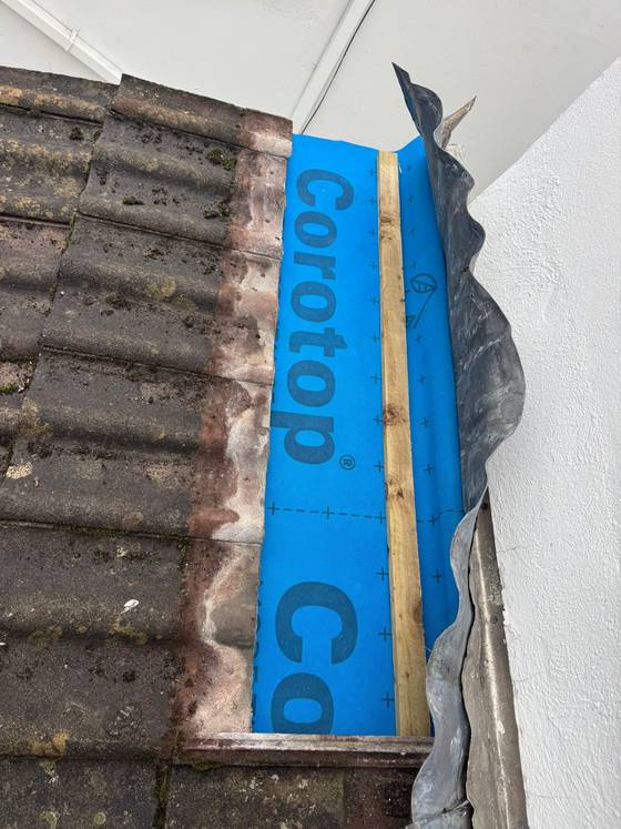Membrane repair at a roof to wall junction